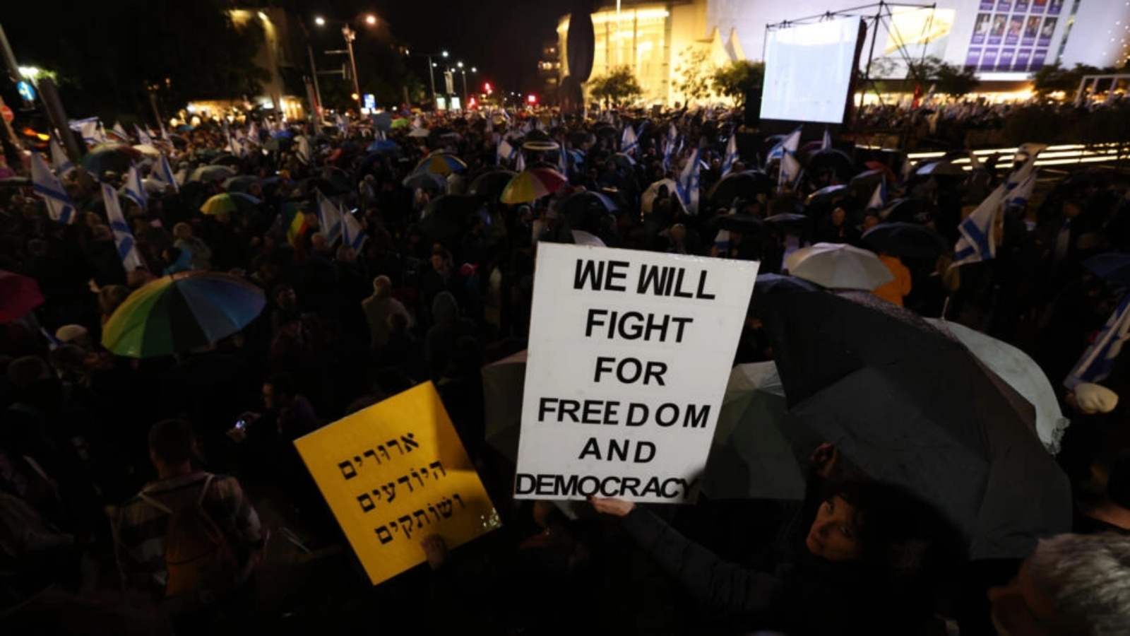 متظاهرون يحملون لافتات خلال تظاهرة ضد حكومة رئيس الوزراء بنيامين نتانياهو اليمينية المتشددة في مدينة تل أبيب الساحلية في 14 يناير 2023 