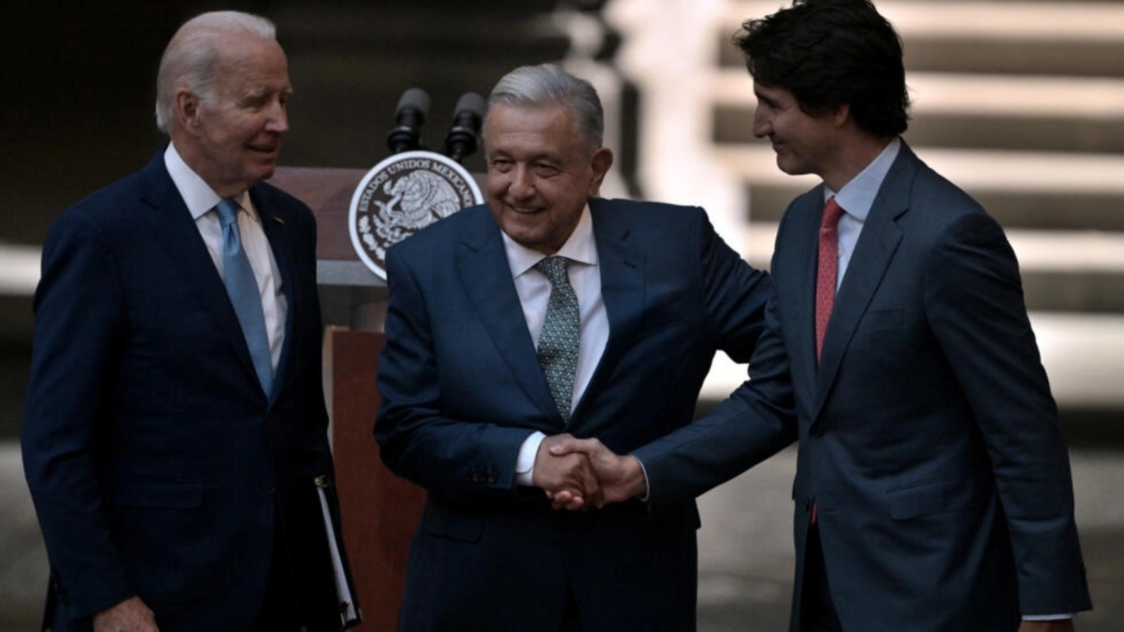 رئيس وزراء كندا جاستن ترودو (يمين) والرئيس المكسيكي أندريس مانويل لوبيز أوبرادور (وسط) يتصافحان أمام الرئيس الأميركي جو بايدن في العاشر من يناير 2023 في مكسيكو على هامش قمة قادة أميركا الشمالية