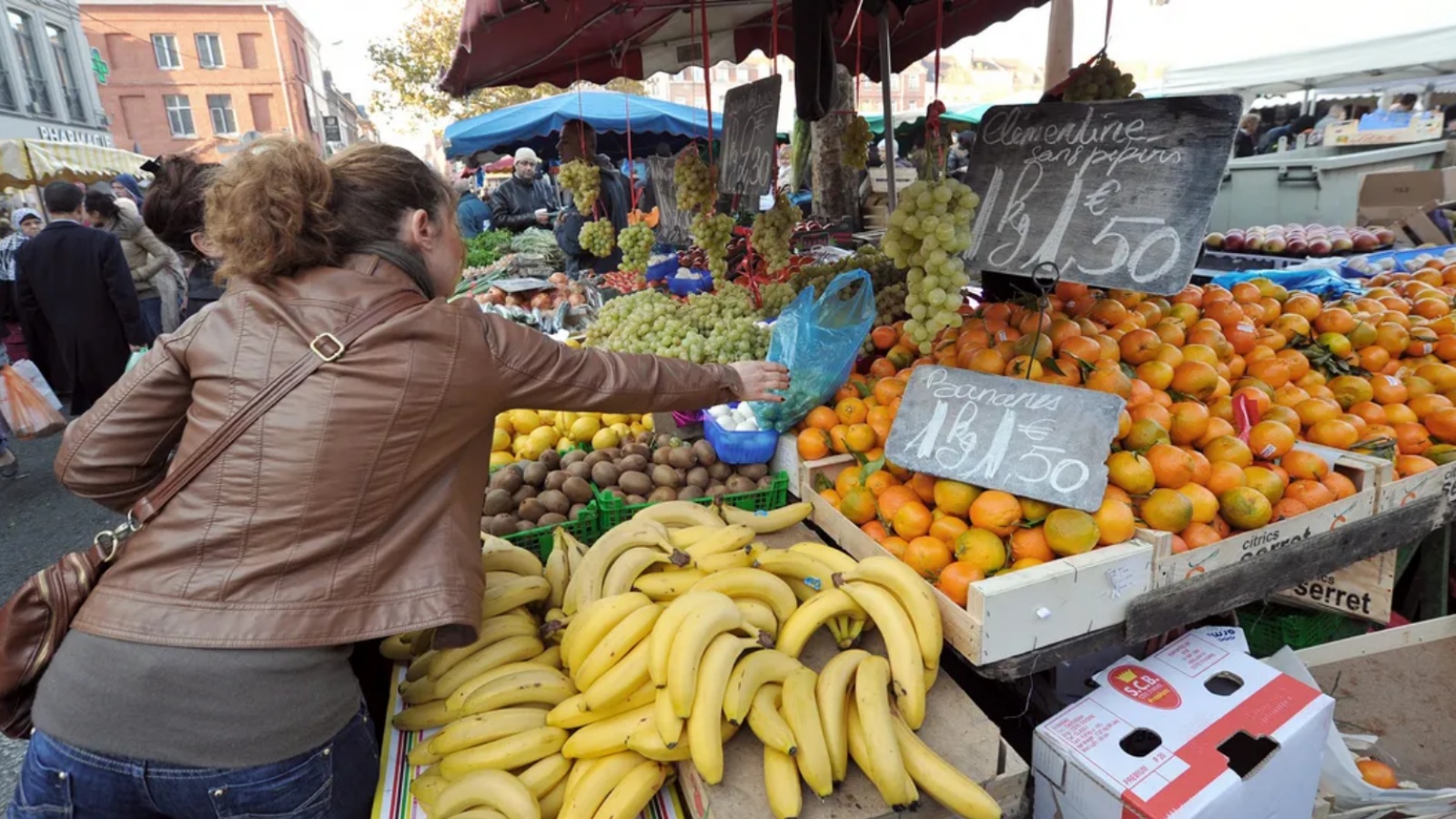 أشخاص يتبضعون في سوق للخضار في فرنسا