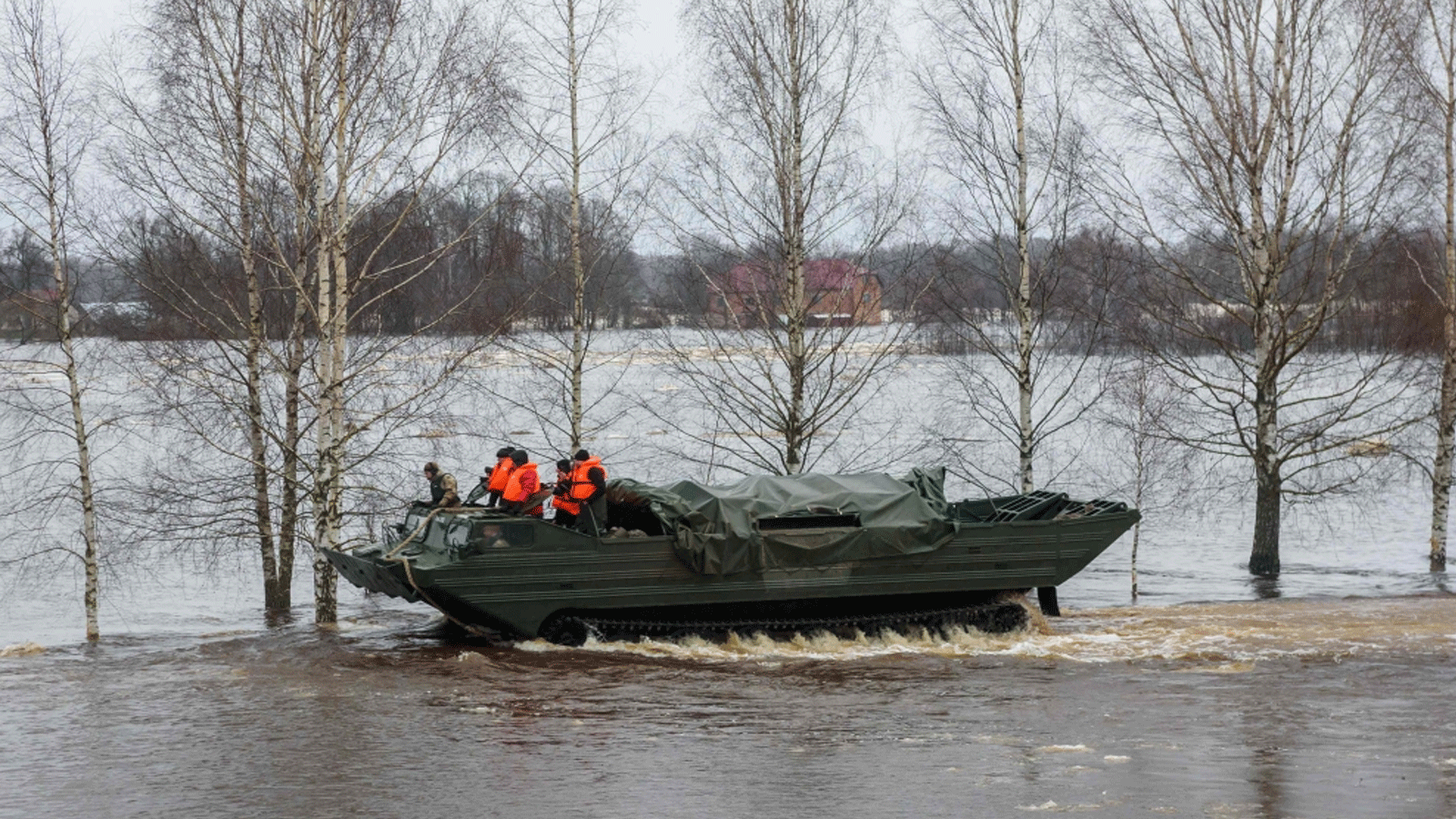 جنود برمائيات عسكرية يشقون طريقهم عبر المناطق التي غمرتها الفيضانات في جيكابيلس، لاتفيا، 15 الثاني\ يناير 2023