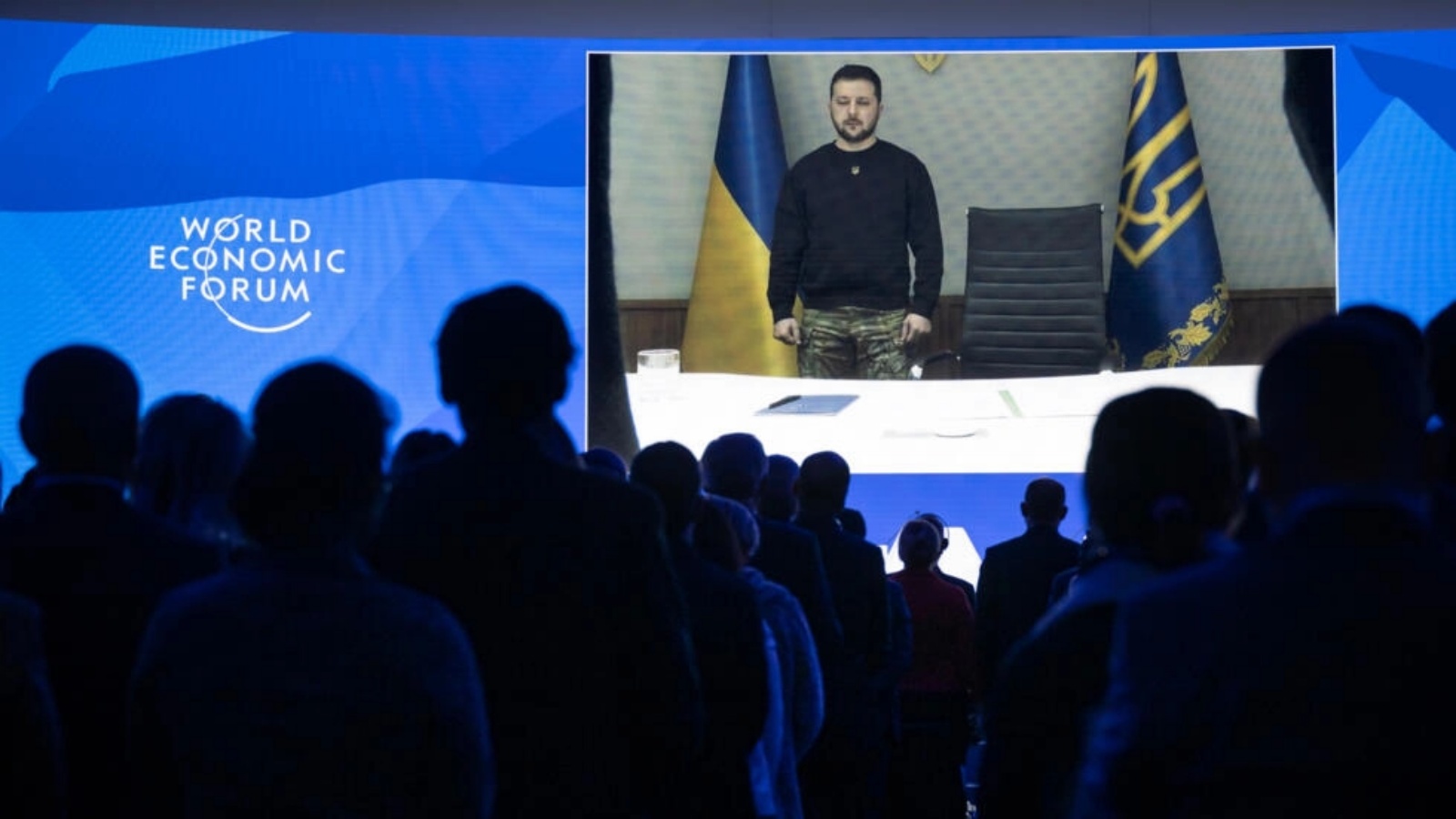 الرئيس الأوكراني فولوديمير زيلينسكي يظهر على شاشة عبر رابط فيديو بينما يقف المشاركون في المنتدى الاقتصادي العالمي دقيقة صمت حداداً على وزير الداخلية الأوكراني الراحل، في مركز المؤتمرات خلال الاجتماع السنوي للمنتدى الاقتصادي العالمي في دافوس في 18 يناير 2023