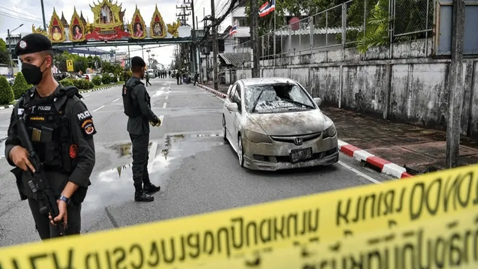 مسؤولو الشرطة بالقرب من سيارة متضررة جزئيًا، بعد انفجار سيارة مفخخة في حادث منفصل خارج مقر الشرطة في منطقة موانغ في مقاطعة ناراثيوات الجنوبية المضطربة في تايلاند