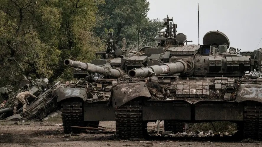 جنود أوكرانيون (يسار) ينقبون دبابة روسية مهجورة من طراز T-90A في كيريليفكا، بالقرب من خاركيف، في 30 سبتمبر 2022