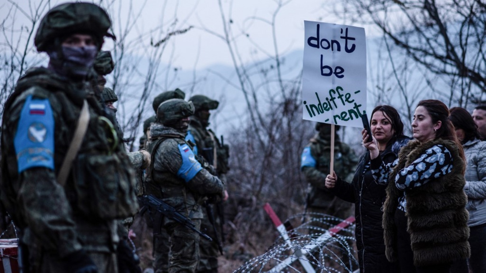 متظاهرون يقفون أمام قوات حفظ السلام الروسية على الطريق خارج ستيباناكيرت ، عاصمة منطقة ناغورنو كاراباخ المزعومة من جانب أذربيجان، في 24 ديسمبر 2022