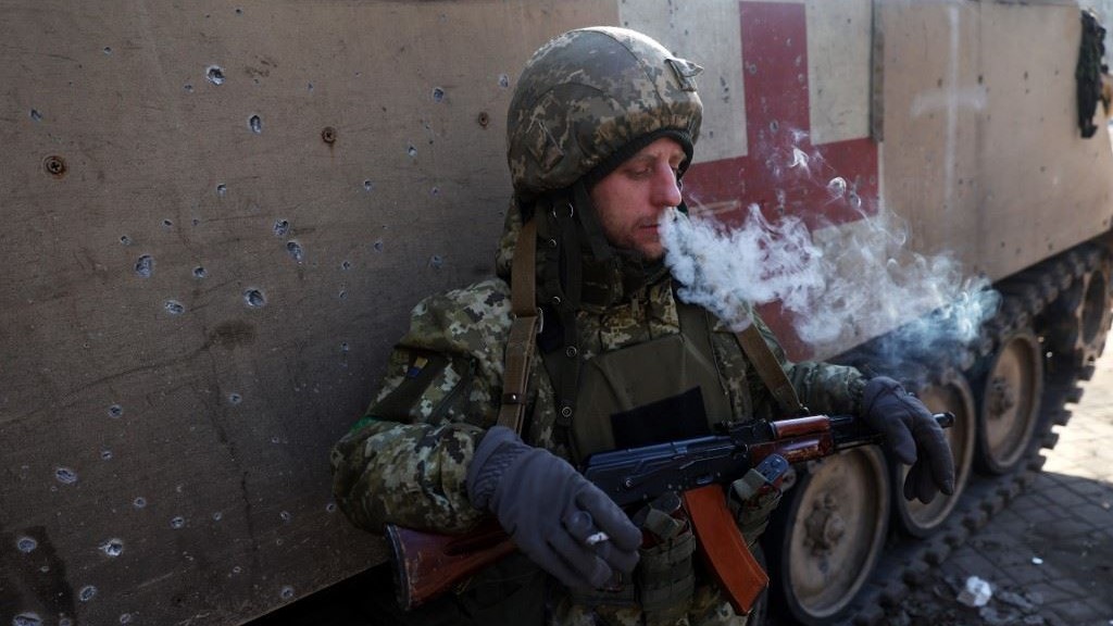 جندي أوكراني يدخن بجانب عربة نقل طبية مصفحة في باخموت بمنطقة دونيتسك في 26 يناير 2023