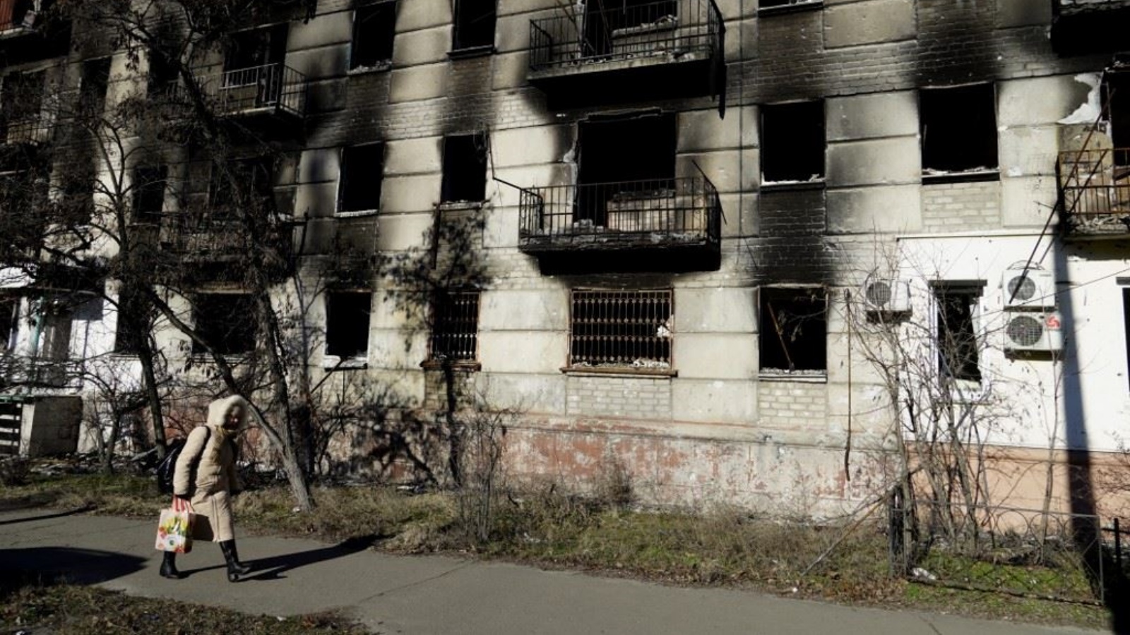 امرأة تمر قرب مبنى سكني مدمر في بلدة سيفيرودونيتسك الخاضعة للسيطرة الروسية في منطقة لوغانسك الشرقية 24 يناير 2023