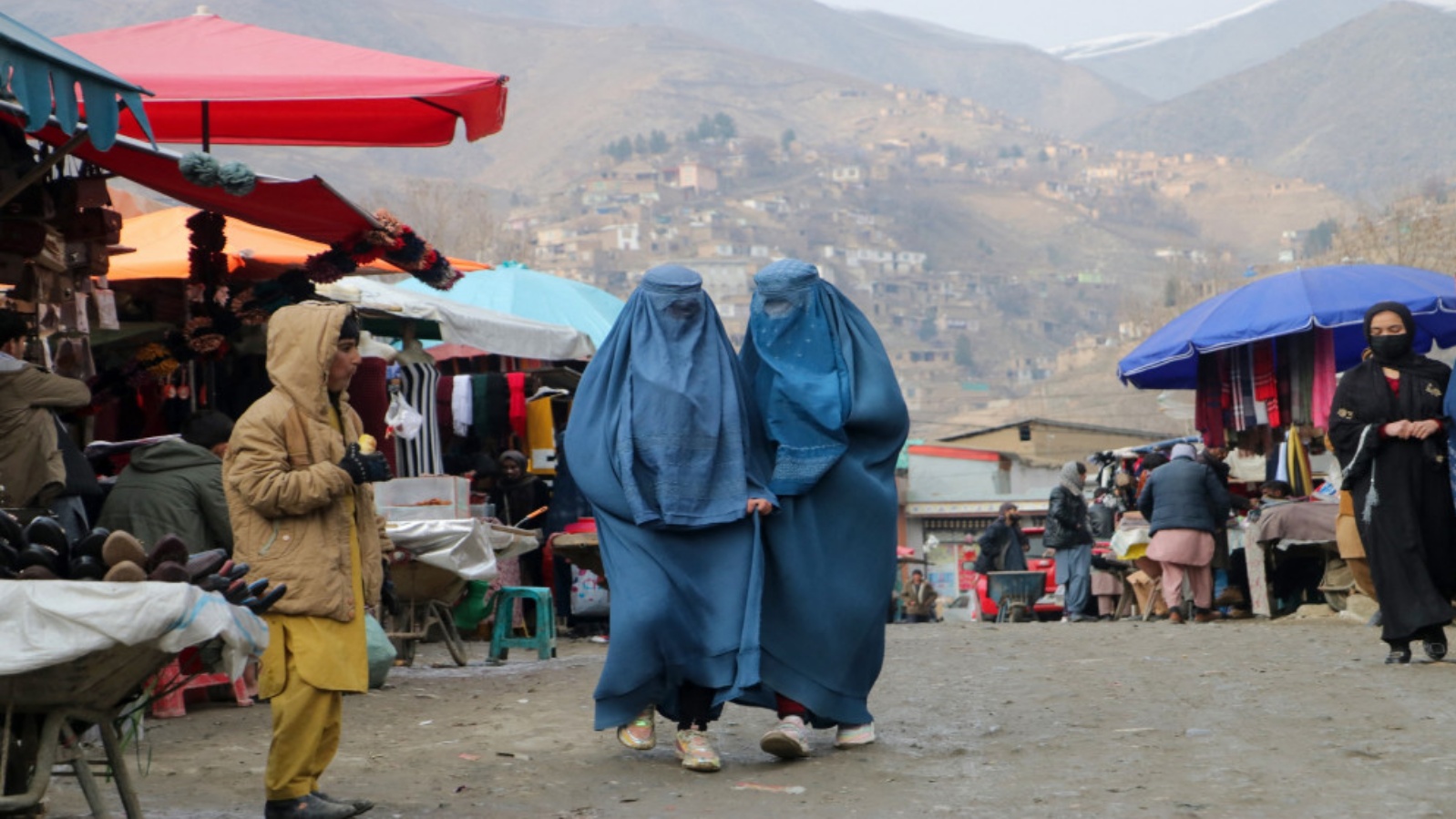 نساء أفغانيات يرتدين البرقع يمشين في سوق في منطقة فايز آباد في مقاطعة بدخشان في أفغانستان، 23 يناير 2023