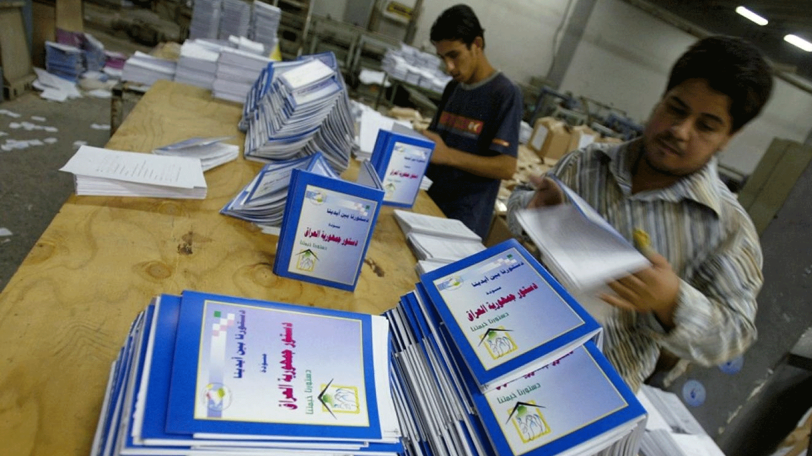 عراقيون يطالعون نسخاً من الدستور الجديد لبلادهم الموافق عليه في استفتاء شعبي عام 2005