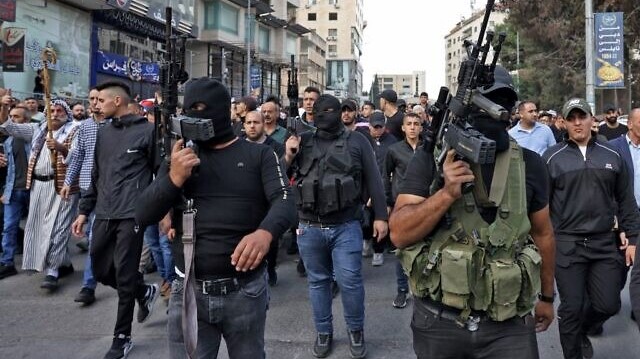 مسلحون فلسطينيون في مسيرة تشييع في نابلس بالضفة الغربية في 25 أكتوبر 2022