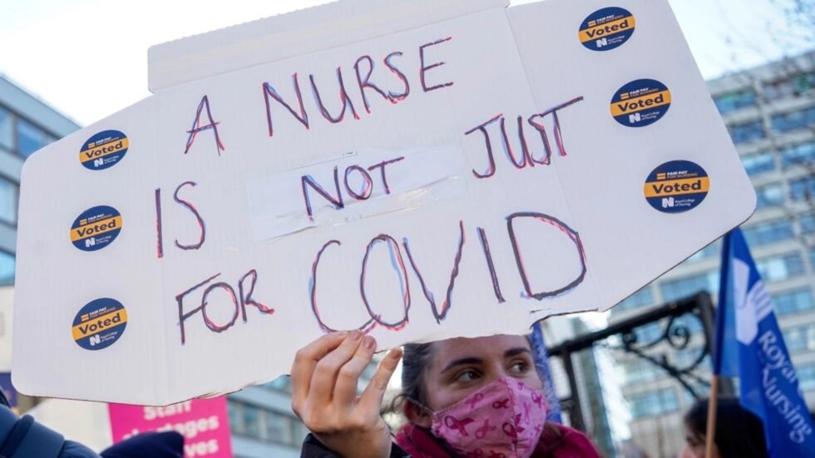 صورة التُقطت في 20 ديسمبر 2022 تُظهر عاملة في المجال الصحي تحمل لافتة مكتوب عليها بالانكليزية 