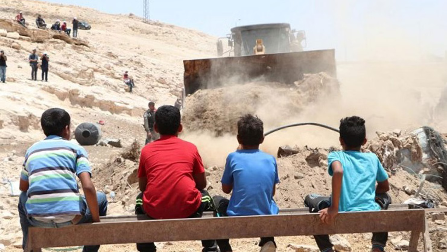 أطفال فلسطينيون يشاهدون الجرافات تزيل أنقاض بيوت مهدمة