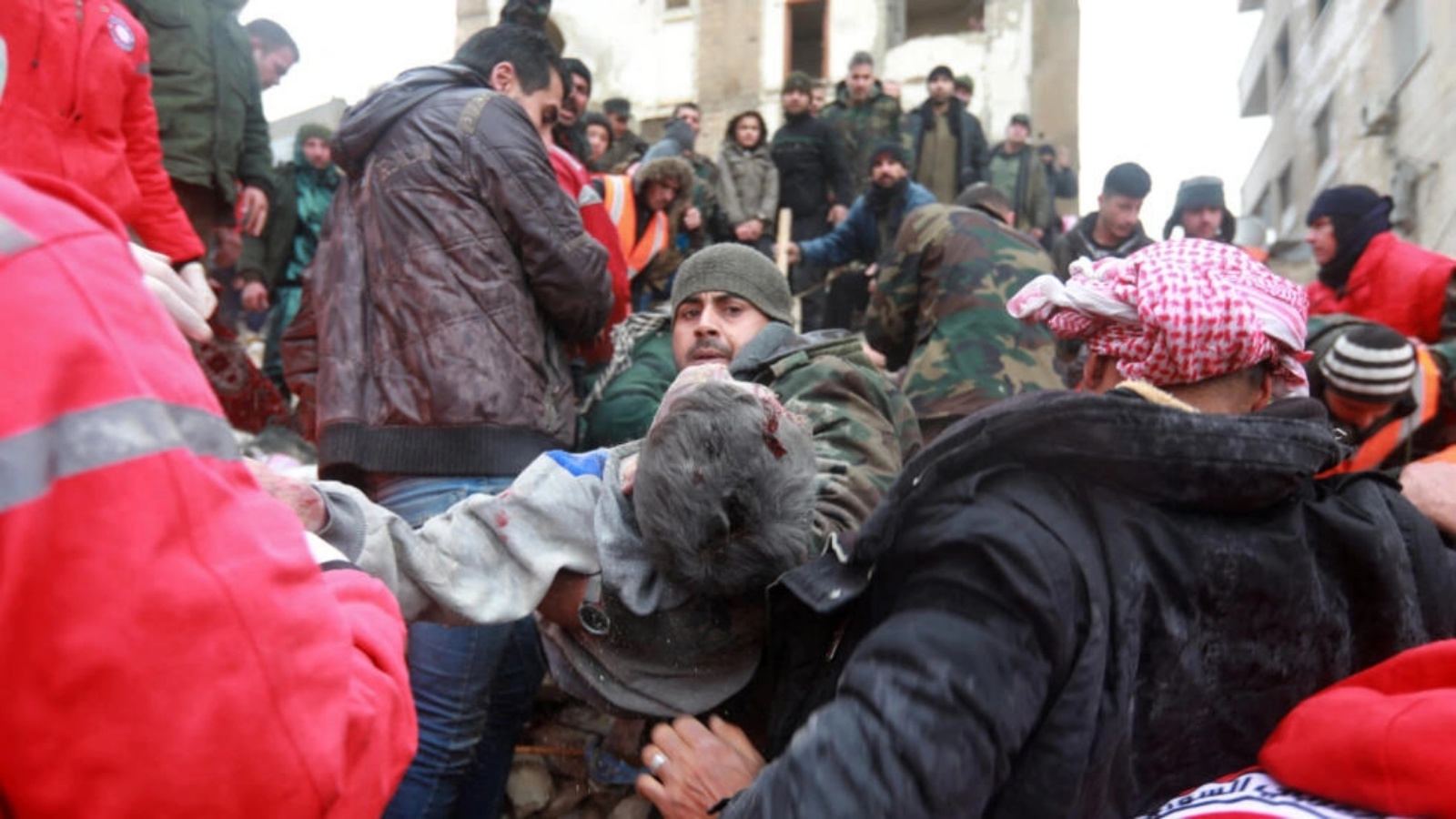 رجل يحمل شخصا تم إخراجه من تحت أنقاض مبنى منهار جراء الزلزال في مدينة حماه وسط سوريا، 6 فبراير 2023
