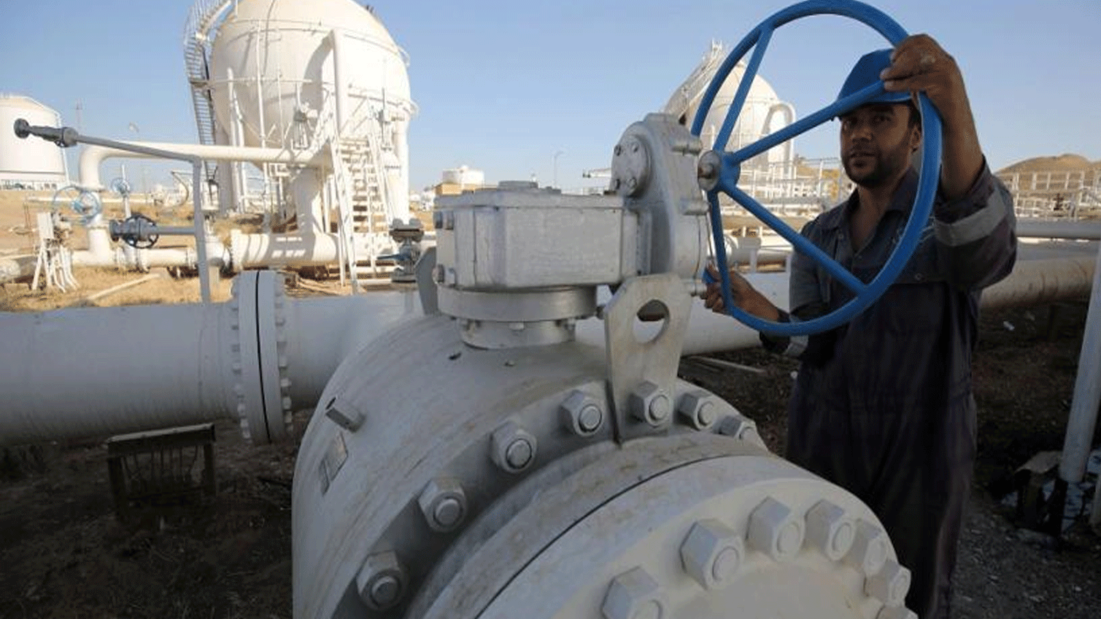 عامل يتفقد خطوط الأنابيب في حقل باي حسن النفطي غربي مدينة كركوك شمال العراق