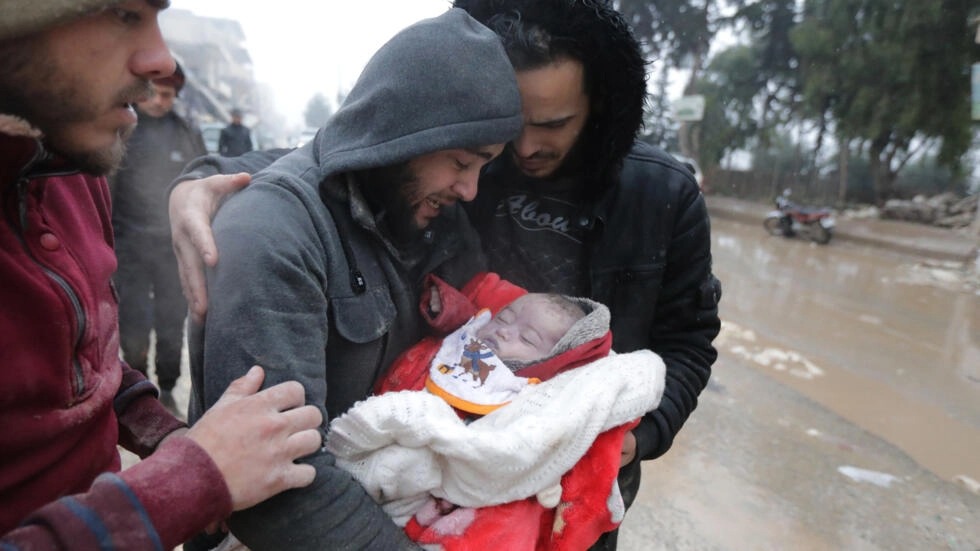 أب مفجوع يحضن رضيعه المتوفي في جنديرس السورية بعد الزلزال المدمر في فبراير 2023