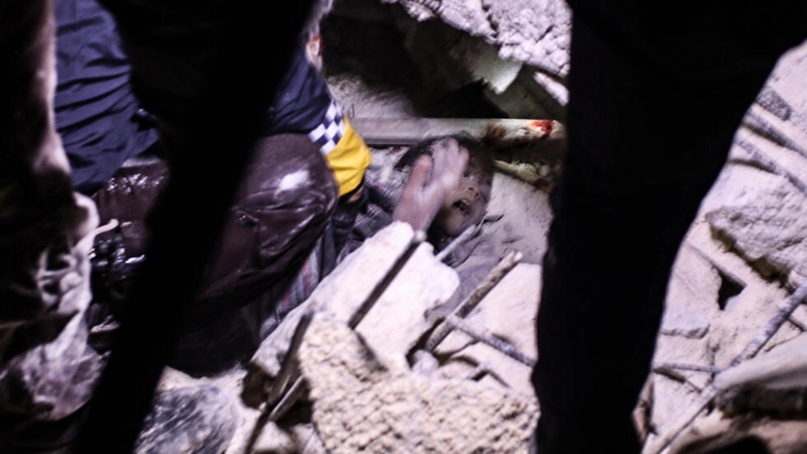 عناصر إنقاذ يحاولون انتشال فتى من تحت ركام مبنى انهار بعد الزلزال في اعزاز بتاريخ 6 فبراير 2023 