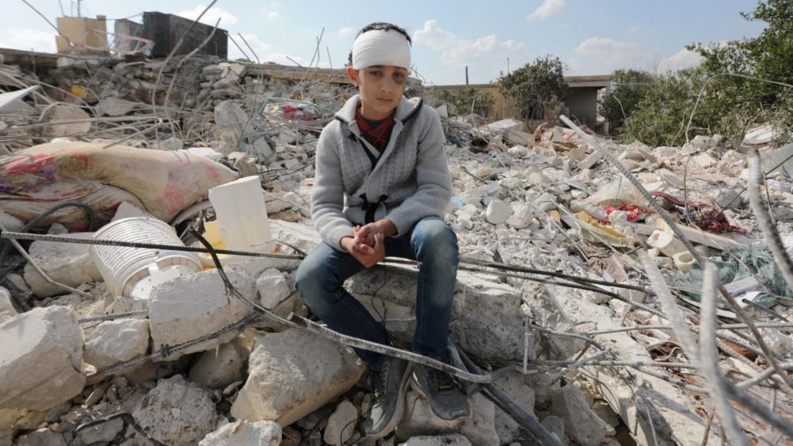 فتى سوري على أنقاض منزل مدمّر في جندريس السورية المنكوبة