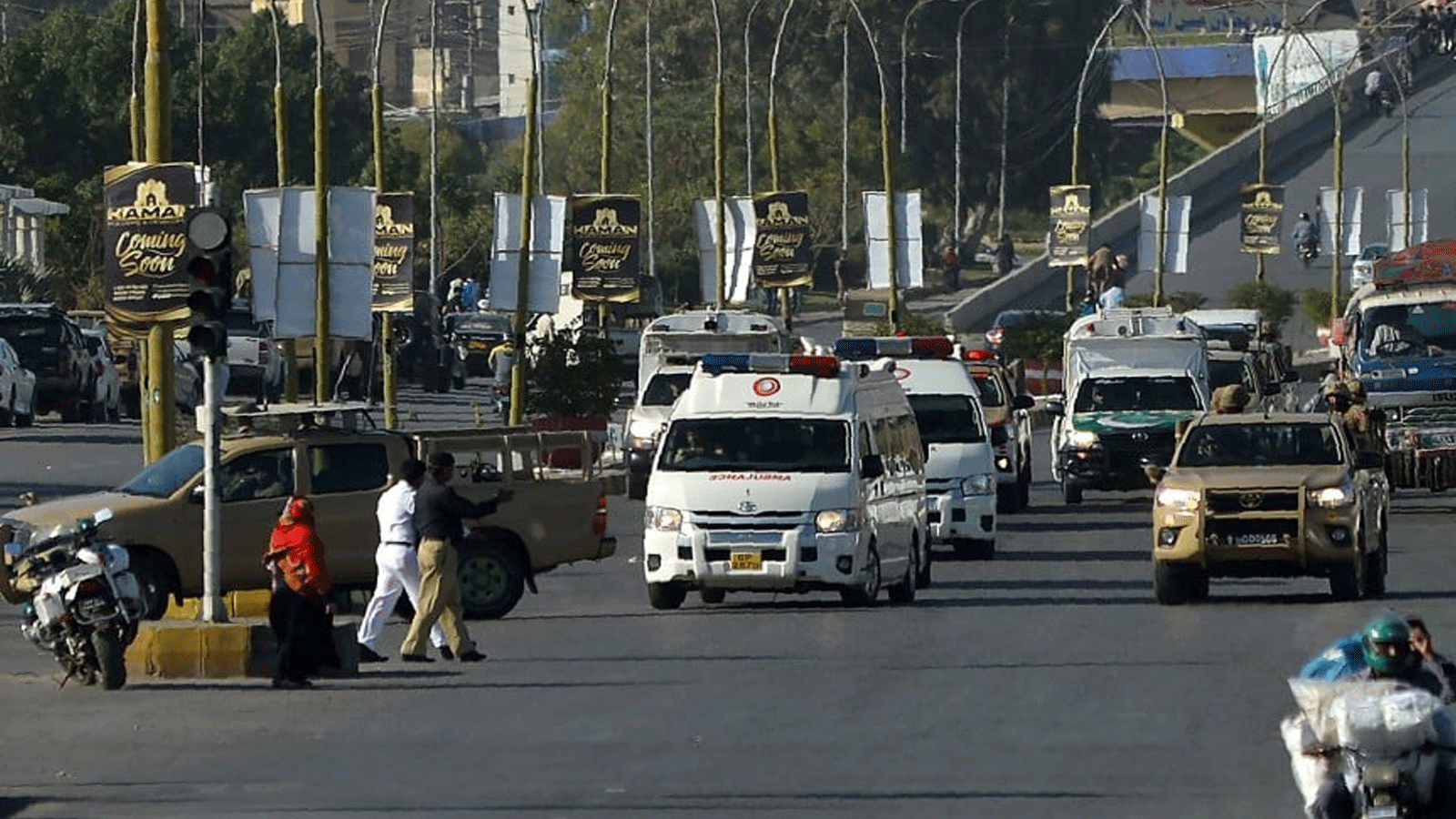 جنود من الجيش يرافقون سيارة إسعاف (على اليسار) تحمل نعش الحاكم العسكري الباكستاني السابق برويز مشرف بعد صلاة الجنازة أثناء نقل جثته إلى مقبرة عسكرية لدفنها في كراتشي