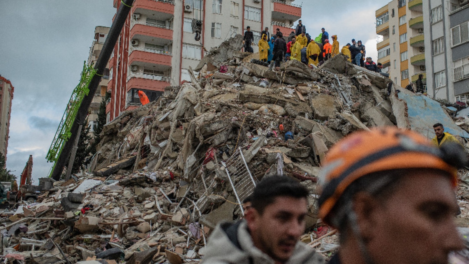 سكان وعمال إنقاذ على أنقاض المباني المدمرة جراء الزلزال