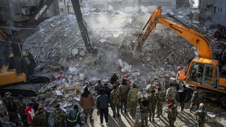 عمال إنقاذ يبحثون عن ناجين تحت أنقاض مبنى منهار في بلدة جبلة في محافظة اللاذقية شمال غرب سوريا بعد زلزال 7 فبراير 2023