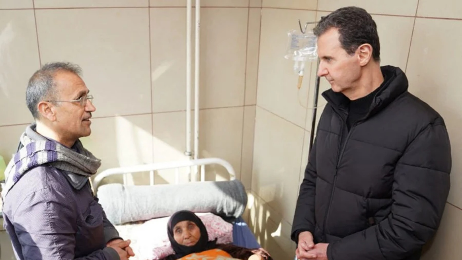 الرئيس السوري بشار الأسد (إلى اليمين) يزور أحد الجرحى الناجين من الزلزال الذي ضرب تركيا وسوريا ، في أحد مستشفيات مدينة حلب شمال سوريا