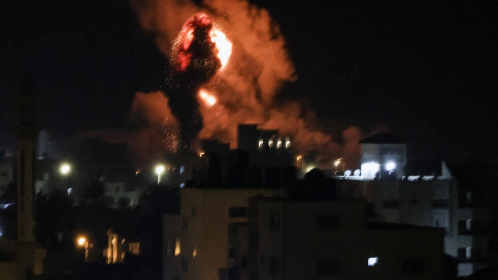 نيران ودخان تتصاعد من أبنية في غزة بعد القصف الإسرائيلي في 13 فبراير 2023