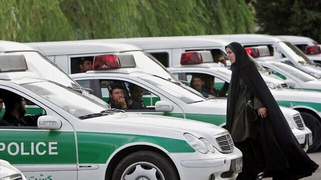 غيرانية تمر أمام سيارات للشرطة في طهران