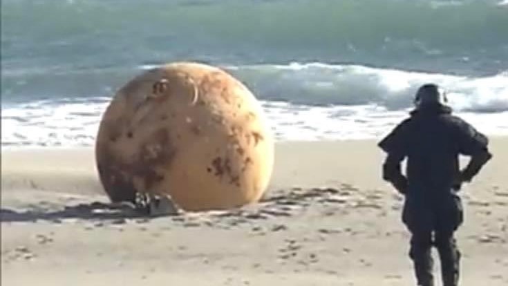 صورة متداولة على تويتر لشرطي ياباني يقترب من الكرة الحديدية المجهولة 