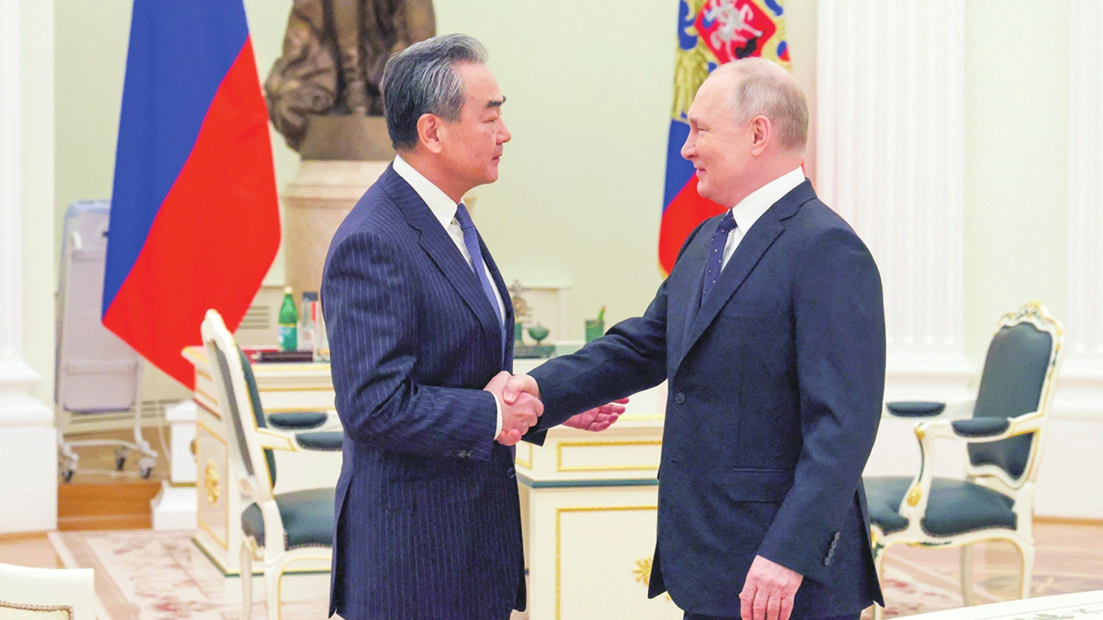 الرئيس الروسي فلاديمير بوتين يصافح رئيس لجنة الشؤون الخارجية الصينية وانغ يي