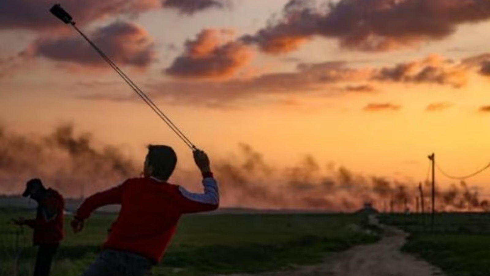 شبان فلسطينيون يرشقون الحجارة باتجاه القوات الإسرائيلية أثناء احتجاجهم بالقرب من الحدود بين إسرائيل وغزة شرق مخيم جباليا للاجئين في 24 فبراير 2023 