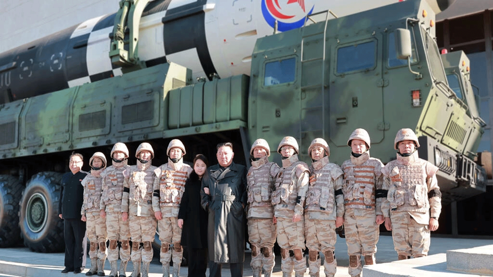 صورة أرشيفية للزعيم الكوري الشمالي مع مسؤولين عسكريين، ويبدو في الخلفية أحد الصواريخ الباليستية