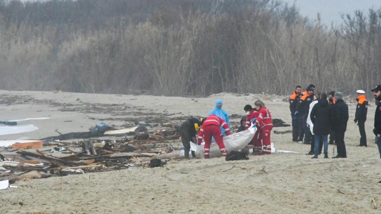 عمال الإنقاذ يتعاملون مع كيس الجثث في موقع حطام سفينة في Steccato di Cutro ، جنوب كروتوني ، بعد غرق قارب مهاجرين قبالة منطقة كالابريا جنوب إيطاليا