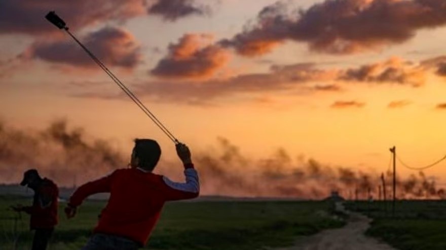 شبان فلسطينيون يرشقون الحجارة باتجاه القوات الإسرائيلية أثناء احتجاجهم بالقرب من الحدود بين إسرائيل وغزة شرق مخيم جباليا للاجئين في 24 فبراير 2023