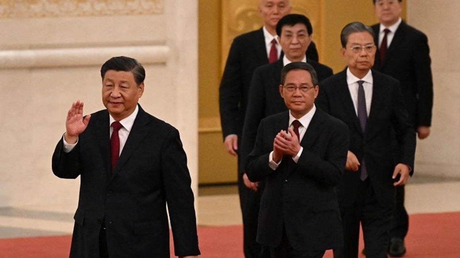 الرئيس الصيني شي جينبينغ (يسار) يسير مع أعضاء اللجنة الدائمة للمكتب السياسي الجديد للحزب الشيوعي الصيني في قاعة الشعب الكبرى في بكين