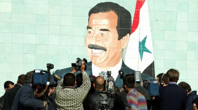 احتشد مصورون أجانب وعراقيون أمام لوحة جدارية للرئيس العراقي الراحل صدام حسين، في عام 2002