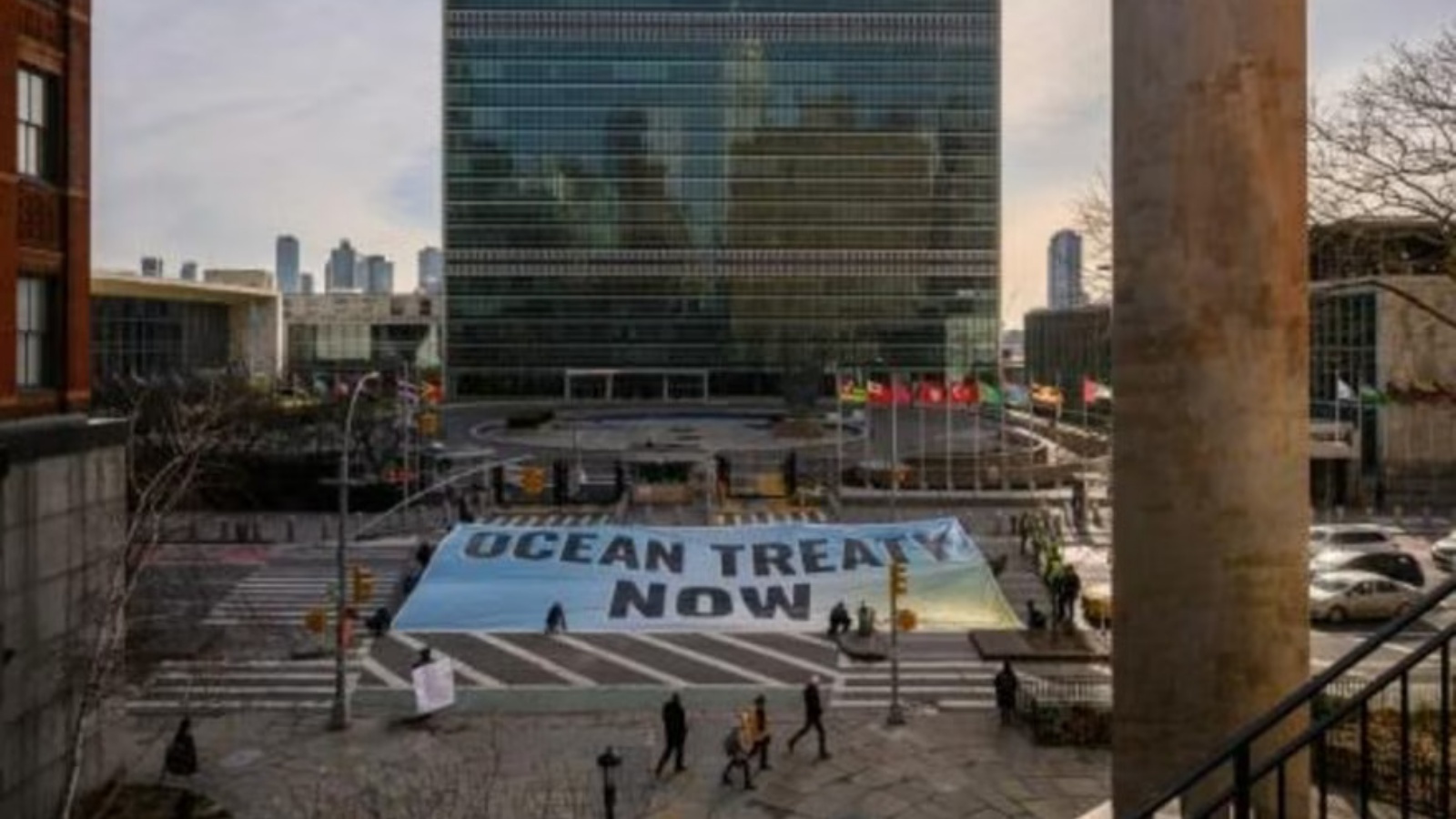 نشطاء من منظمة غرينبيس يعلقون لافتة أمام مقر الأمم المتحدة خلال مفاوضات مستمرة حول معاهدة حماية أعالي البحار، في نيويورك في 27 فبراير 2023 