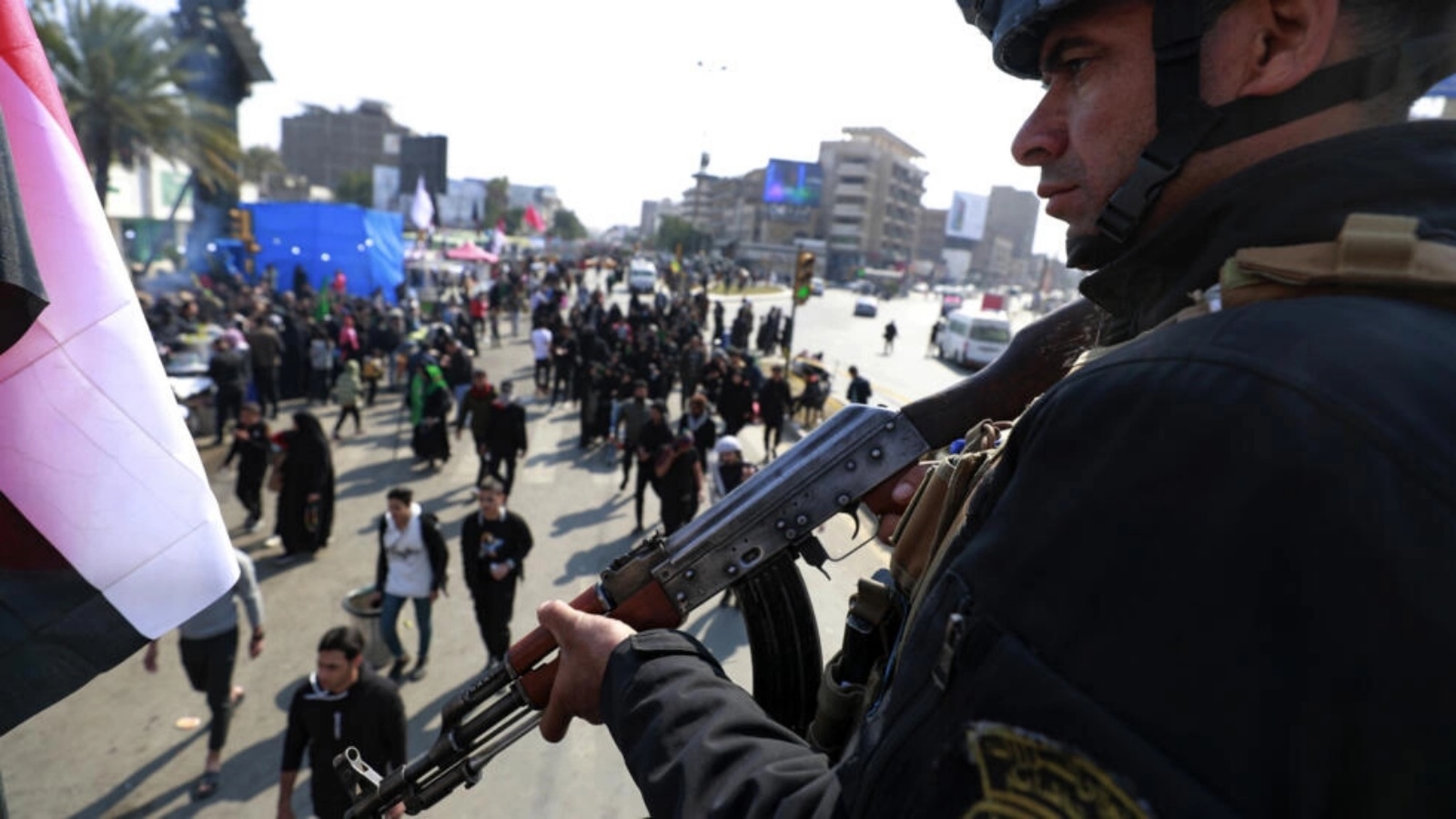 عنصر من القوات الأمنية يقوم بحراسة زوار متجهين إلى مرقد الإمام الكاظم في بغداد في 15 فبراير 2023 