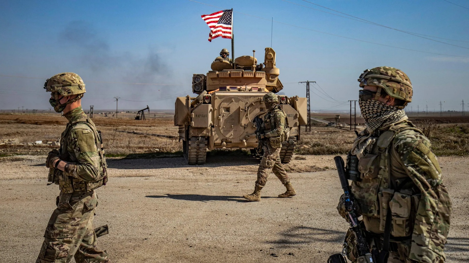 جنود أميركيون يسيرون أثناء دورية بالقرب من حقول النفط بالسويدية في محافظة الحسكة شمال شرق سوريا عام 2021