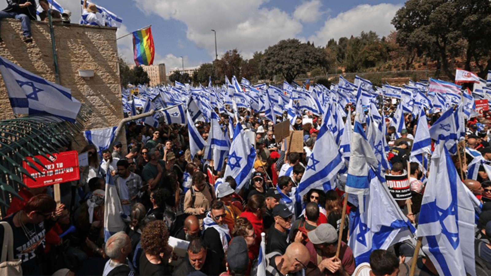 متظاهرون يتجمعون بالأعلام الوطنية خارج البرلمان الإسرائيلي وسط مظاهرات مستمرة في القدس ويدعون إلى إضراب عام ضد المساعي المثيرة للجدل للحكومة اليمينية المتشددة لإصلاح نظام العدالة، في 27 مارس 2023
