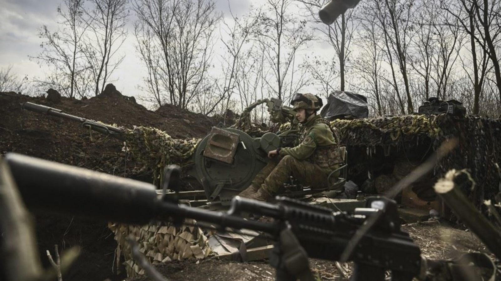 جندي أوكراني يجلس على مدفع مضاد للطائرات