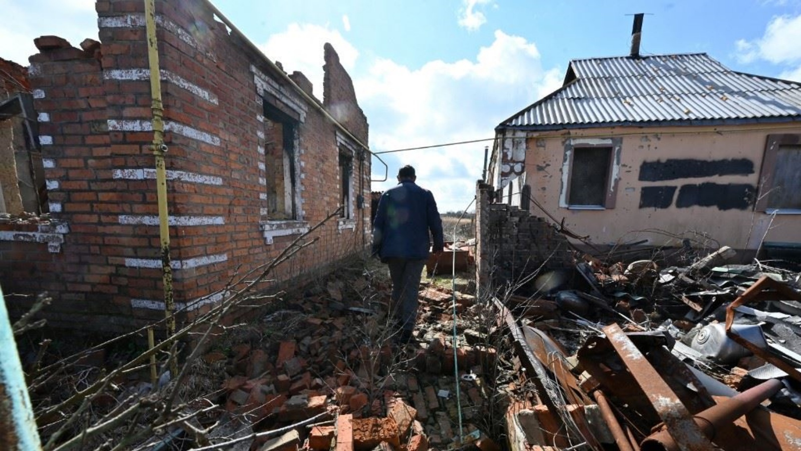 أحد السكان المحليين يمر قرب منازل مدمرة في قرية روسكيي تيشكي شمال منطقة خاركيف 27 مارس 2023