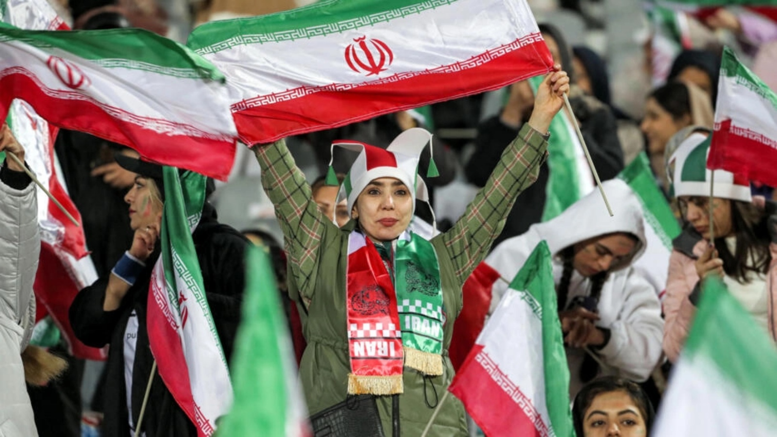 مشجّعات كرة قدم يحملن أعلامًا إيرانية خلال مباراة بين المنتخب الإيراني والمنتخب الروسي في طهران في 23 مارس 2023 