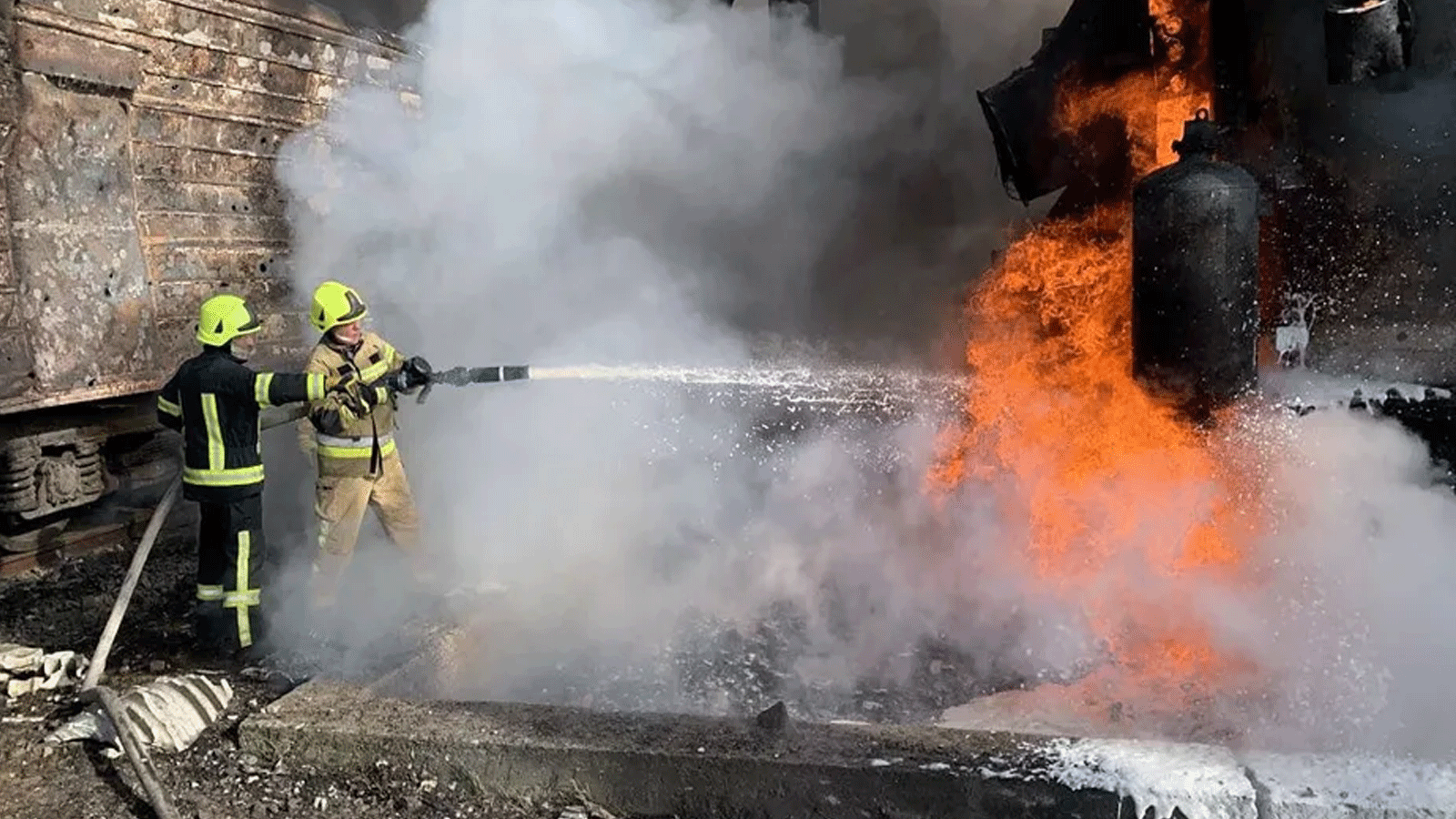رجال الإطفاء الأوكرانيون يحاولون إخماد حريق في منشآت الطاقة في منطقة ريفني (غرب أوكرانيا) في 22 تشرين الأول\أكتوبر 2022