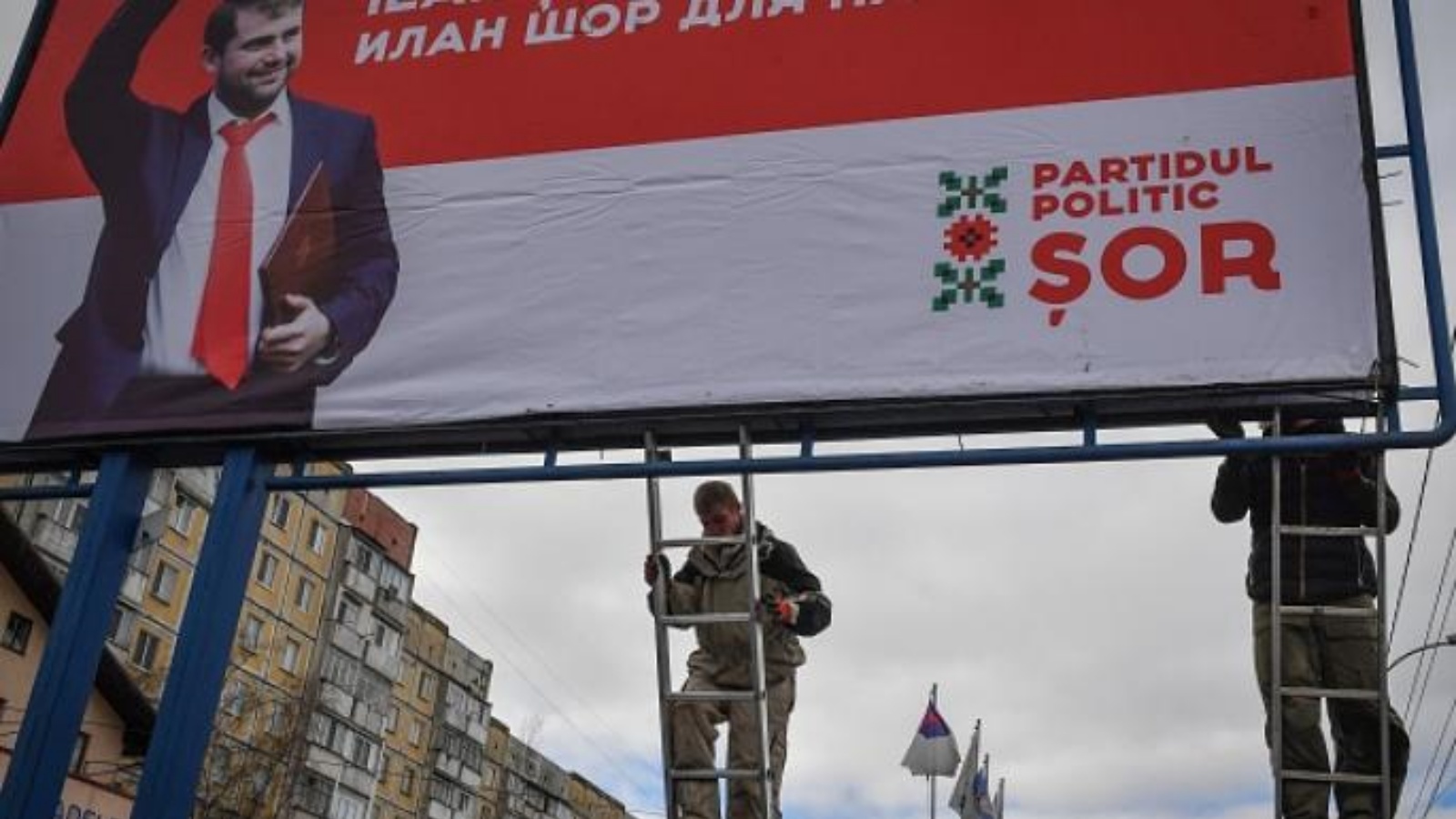 عمال ينصبون إعلاناً للحملة الانتخابية لإلهان شور الموالي لروسيا عام 2019