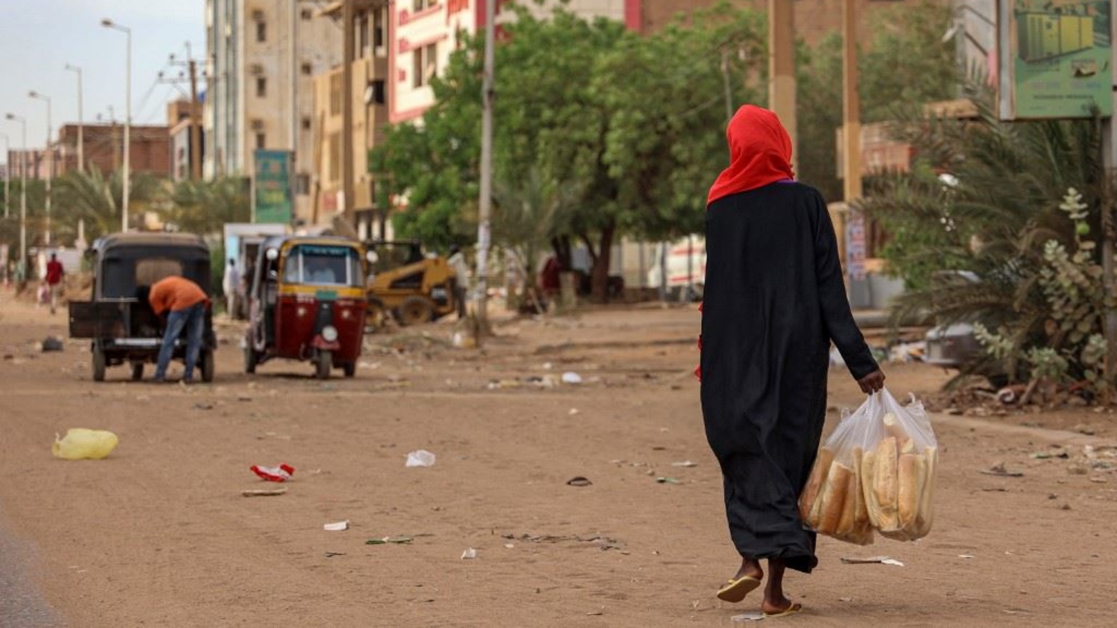 امرأة تحمل أكياس خبز خلال سيرها في أحد شوارع الخرطوم 18 أبريل 2023