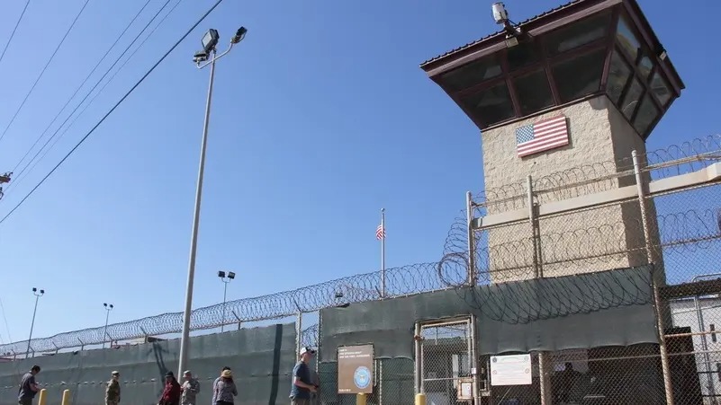 أشخاص يمرون بجانب برج حراسة خارج سياج المعسكر 5 في سجن الجيش الأمريكي في خليج غوانتانامو ، كوبا ، 26 يناير 2017