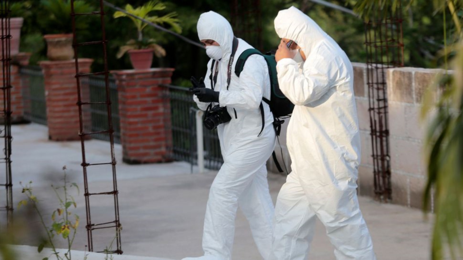 خبراء الطب الشرعي أمام المشرحة حيث تم العثور على 28 جثة في مقبرة جماعية مخزنة، في بويبلو فيجو، بالقرب من إيغوالا، في ولاية غيريرو، في 5 أكتوبر 2014 في المكسيك