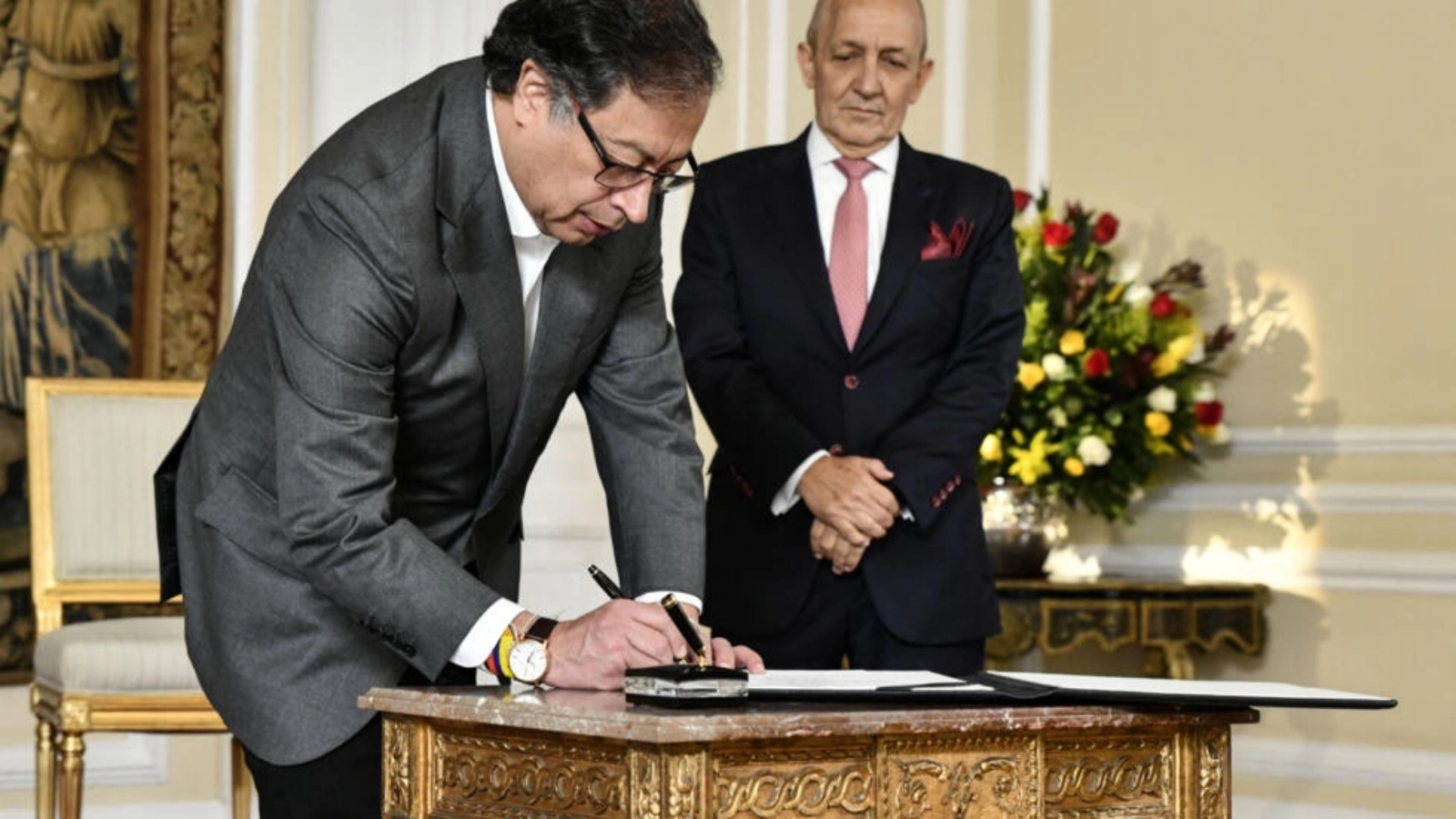 الرئيس الكولومبي غوستافو بيترو (يسار) يوقع وثيقة بجانب مستشار الدولة الجديد خورخي دوكي في بوغوتا، 26 أبريل 2023