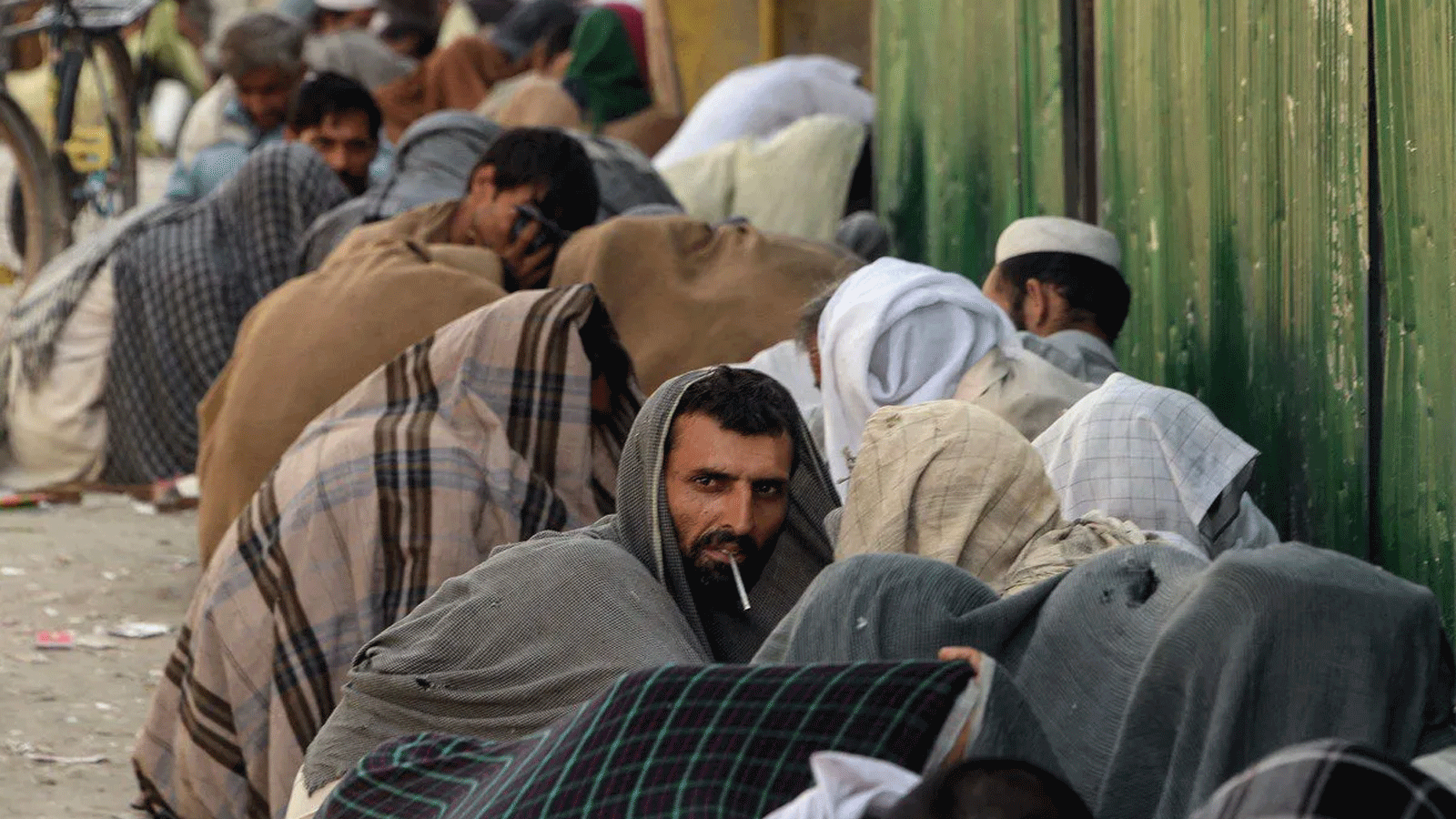 مدمنو المخدرات الأفغان يدخنون الهيروين في أحد شوارع جلال أباد، أفغانستان