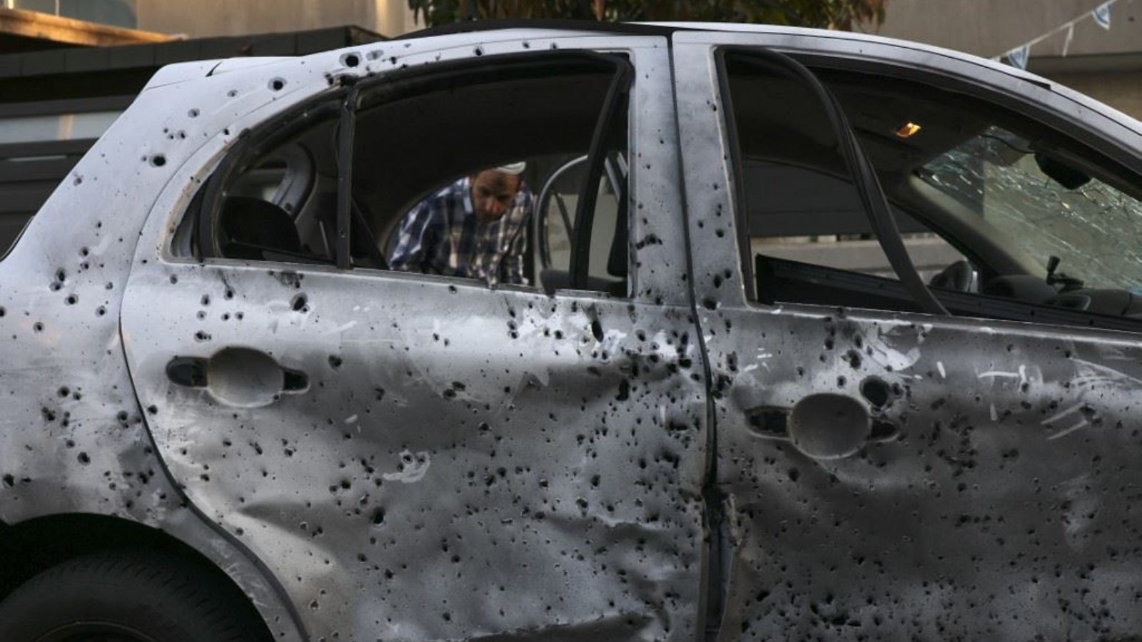 رجل يتفقد سيارة مدمرة في مدينة سديروت جنوب إسرائيل في أعقاب قصف بين إسرائيل وغزة 2 مايو 2023