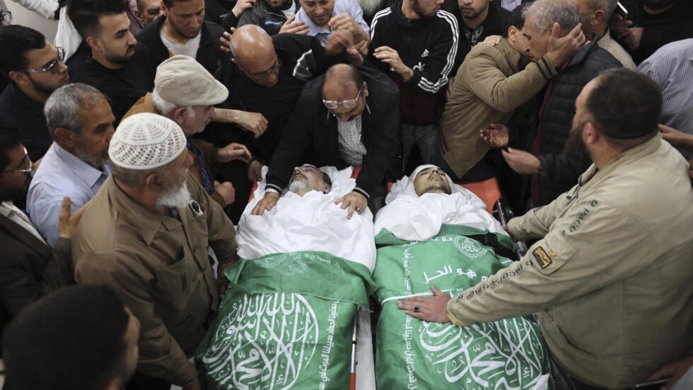 فلسطينيون يتجمعون حول جثمان الطبيب الروسي-الفلسطيني جمال خصوان ونجله في مشرحة في مدينة غزة في 9 من مايو 2023 بعد غارات جوية إسرائيلية على القطاع